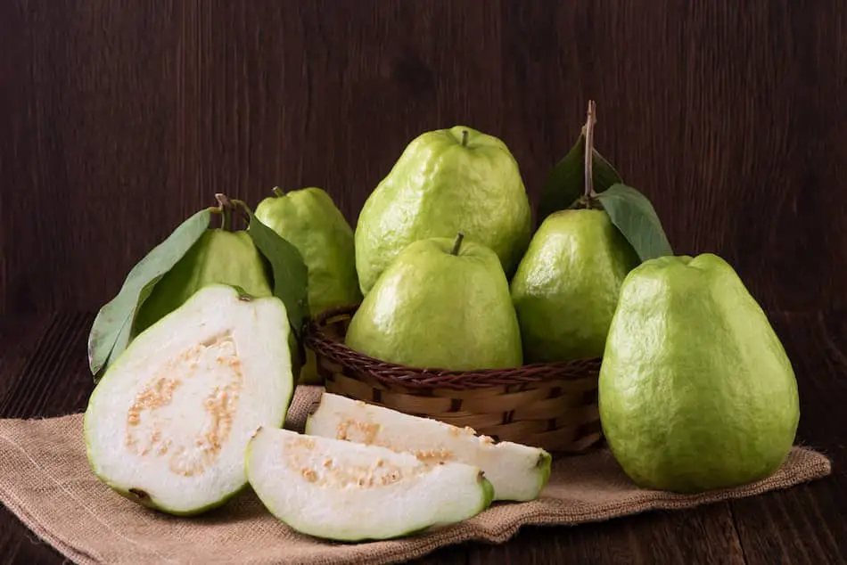 Photograph of whole and cut, white guava fruit
